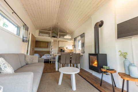 Modernes Interieur von Tiny House 4 in De Achterhoek, Niederlande, mit Kamin und Schlafboden.