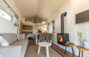 Interior moderno de Tiny House 4 en De Achterhoek, Países Bajos, con chimenea y altillo dormitorio.