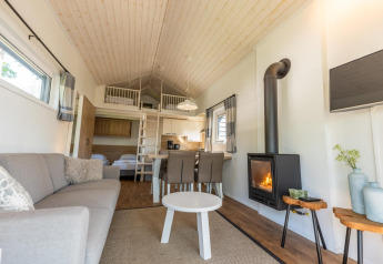 Modern interieur van Tiny House 4 in De Achterhoek, Nederland, met haard en slaapverdieping.
