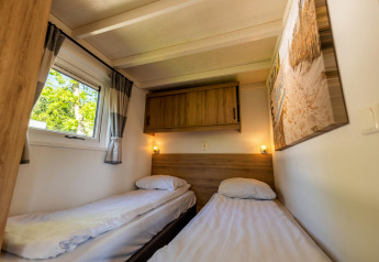 Værelse med to enkeltsenge, garderobe og vindue på Tiny House 4 i De Achterhoek, Nederlandene.
