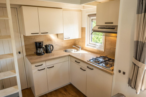 Kompakte, moderne Küche im Tiny House 4 bei De Achterhoek in den Niederlanden mit Gasherd und Kaffeemaschine.