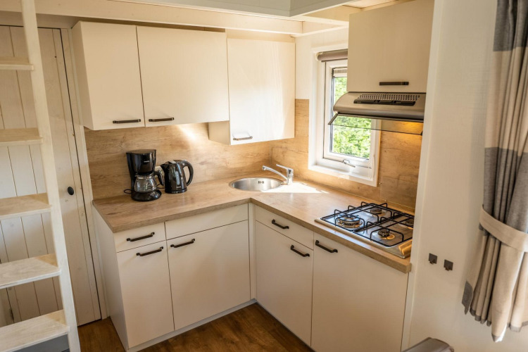 Cocina compacta y moderna en Tiny House 4 de De Achterhoek, Países Bajos, con estufa y cafetera.