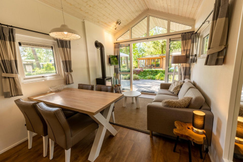 Helles Interieur einer Lodge namens Tiny House 4 in De Achterhoek, Niederlande, mit Gartenblick.
