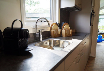 Moderne gootsteen en koffiemachine in Baby Cottage lodge, Kaatsheuvel, Nederland, met daglicht.