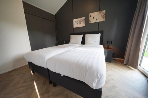 Chambre moderne au Baby cottage lodge à Kaatsheuvel, Pays-Bas, avec lits jumeaux et décoration élégante.