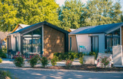 Moderne Berkel-Lodge in Kaatsheuvel, Niederlande, mit großen Fenstern und blühenden Pflanzen davor.