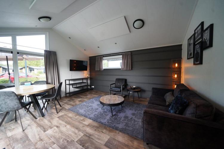 Modernes Wohnzimmer in der Berkel-Lodge in Kaatsheuvel, Niederlande, mit stilvollen Möbeln und Fenstern.