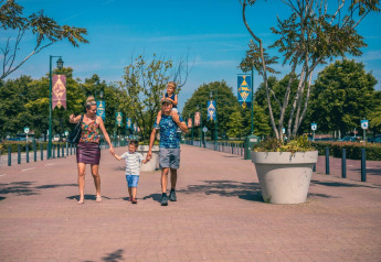 Eine Familie spaziert bei sonnigem Wetter vor dem Pavilion Maximaal in Kaatsheuvel, Niederlande.