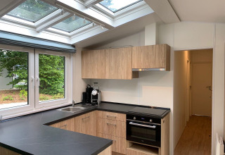 Moderne Küche in der Berkel-Lodge in Kaatsheuvel, Niederlande, mit Oberlicht und Holzschränken.