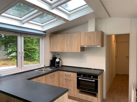 Cocina moderna en la cabaña Berkel de Kaatsheuvel, Países Bajos, con tragaluces y gabinetes de madera.