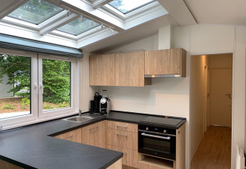 Moderne keuken in lodge Berkel te Kaatsheuvel, Nederland, met dakramen en houten keukenkasten.