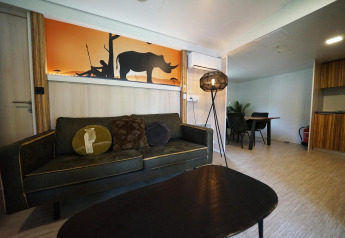 Salón en una cabaña en Kaatsheuvel, Países Bajos, con sofá, mesa y arte de pared de rinoceronte.