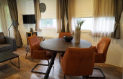 Comedor moderno con mesa redonda, sillas naranjas y decoración en una cabaña en Kaatsheuvel, Países Bajos.