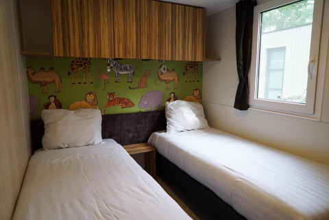 Habitación infantil con dos camas individuales, mural animal y ventana en Cottage en Kaatsheuvel, Países Bajos.