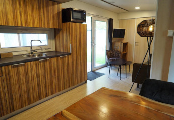 Moderne lodge i Kaatsheuvel, Holland, med træinventar, tekøkken, spisebord og hyggeligt opholdsområde.