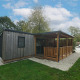 Holzferienhaus mit überdachter Veranda im Cottage at Kaatsheuvel, Niederlande, mit Gartenansicht.