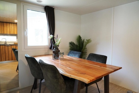 Comedor con mesa de madera natural y cuatro sillas en Cottage at Kaatsheuvel, Países Bajos.