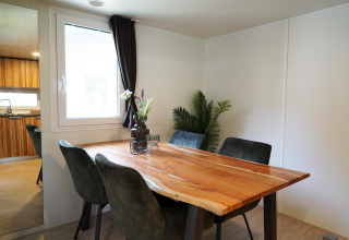 Dining area with a live-edge wood table, four chairs and decor in Cottage at Kaatsheuvel, Netherlands.