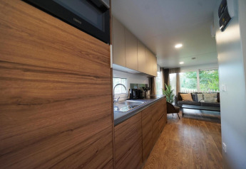 Cocina moderna y sala de estar en Cottage at Kaatsheuvel, Países Bajos, con suelos y detalles en madera.