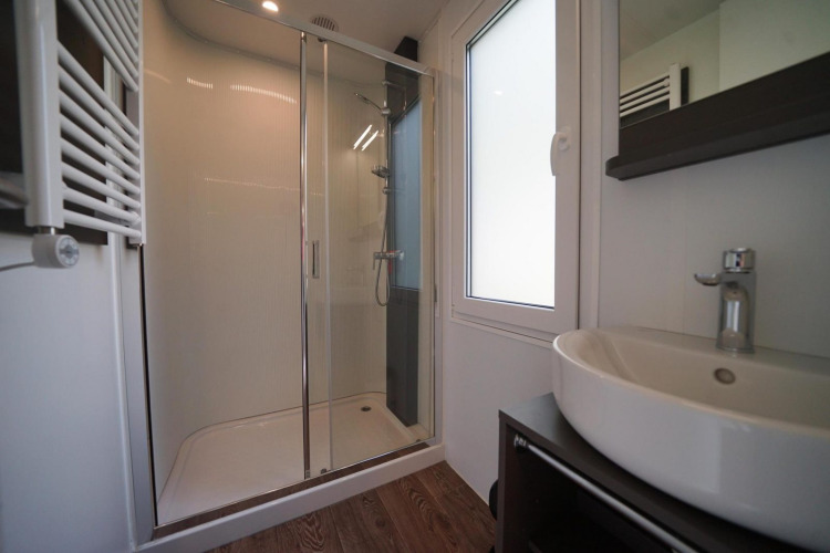 Modern bathroom with glass shower and sink in a lodge at Cottage at Kaatsheuvel, Netherlands.