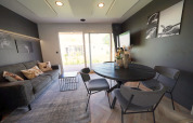 Modern lounge at Domus lodge in Kaatsheuvel, Netherlands, with dining table, sofa and garden view.