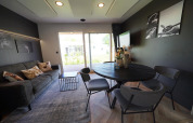 Modernes Wohnzimmer in der Domus Lodge, Kaatsheuvel, Niederlande mit Esstisch, Sofa und Gartenausblick.