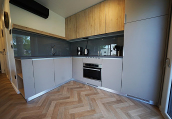 Moderne keuken in Domus lodge in Kaatsheuvel, Nederland, met houten afwerking en ingebouwde toestellen.