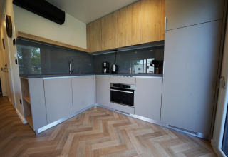 Modern kitchen interior at Domus lodge in Kaatsheuvel, Netherlands, with wood accents and built-in appliances.