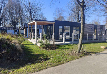 Moderne Domus-Lodge in Kaatsheuvel, Niederlande, mit Holzterrasse, großen Fenstern und ruhiger Umgebung.