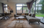 Modernes Wohnzimmer in der Pavilion Maximaal Lodge, Kaatsheuvel, Niederlande, mit großen Fenstern.