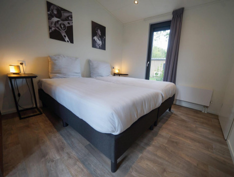 Slaapkamer in Pavilion Maximaal lodge in Kaatsheuvel, Nederland, met twee bedden en moderne inrichting.