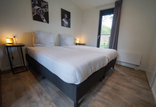 Dormitorio en el lodge Pavilion Maximaal en Kaatsheuvel, Países Bajos, con dos camas y decoración moderna.