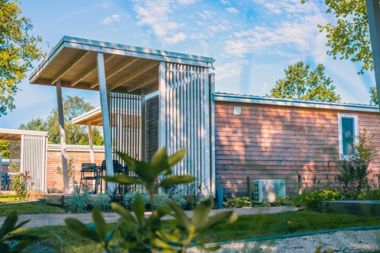 Moderna cabaña Tiny Cottage en Kaatsheuvel, Países Bajos, con fachada de madera y terraza exterior cubierta.