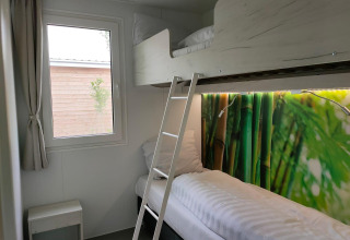 Et lille værelse i Tiny Cottage ved Kaatsheuvel, Holland, med køjesenge og farverigt bambus-motiv.