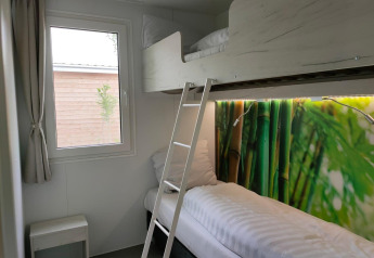 Et lille værelse i Tiny Cottage ved Kaatsheuvel, Holland, med køjesenge og farverigt bambus-motiv.