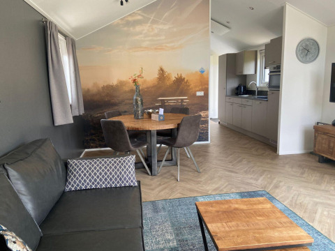 Lodge Velthorst a Kaatsheuvel, Paesi Bassi, interno moderno con soggiorno, cucina e murale paesaggistico.