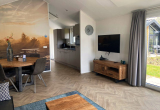 Helles Wohnzimmer einer Velthorst-Lodge in Kaatsheuvel, Niederlande, mit Holzdekor und Wandbild.