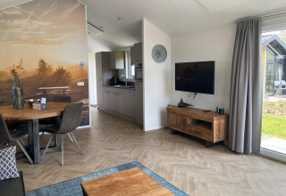 Sala moderna en un lodge Velthorst en Kaatsheuvel, Países Bajos, con suelos de madera y gran mural.