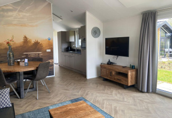 Moderne lodge woonkamer bij Velthorst in Kaatsheuvel, Nederland, met houten vloer en wanddecoratie.
