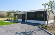 Chalet Velthorst en Kaatsheuvel, Países Bajos, moderno edificio con entrada de grava y jardín verde.