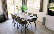 Bright and modern dining area at Velthorst glamping accommodation with table set for six guests.