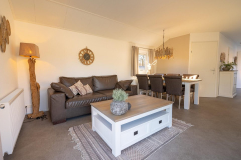 Living room in Velthorst chalet, Kaatsheuvel, Netherlands with leather sofa, dining table, and decor.