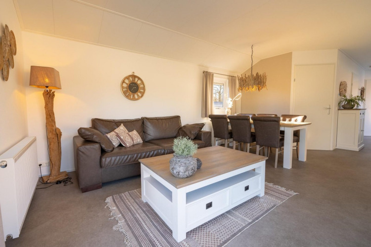 Sala de estar en el chalet Velthorst en Kaatsheuvel, Países Bajos, con sofá de cuero y mesa comedor.