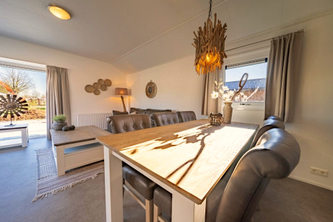 Modernes Chalet in Velthorst, Kaatsheuvel, Niederlande mit hellem Esstisch, stilvollen Möbeln und gemütlichem Ambiente.