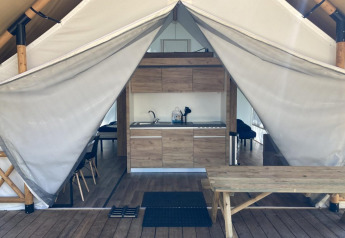 Vista interna di una tenda glamping con cucina e tavolo da picnic a Kaatsheuvel, Paesi Bassi.