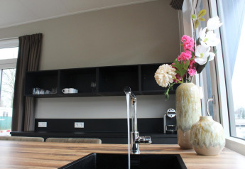 Cocina de lodge moderna con encimera de madera, fregadero negro y flores en Just Nature, Kaatsheuvel, Países Bajos.