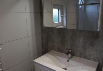 Moderne badeværelsesvask og spejl med vindue på lodge Just Nature i Kaatsheuvel, Holland.