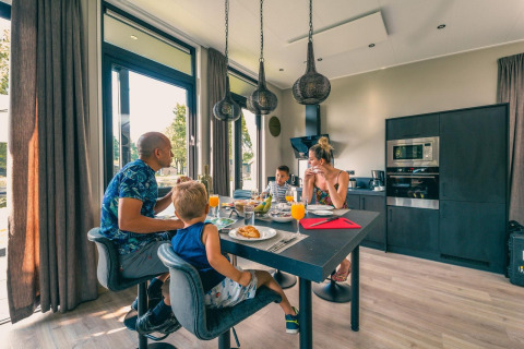 Famille prenant le petit-déjeuner ensemble dans un lodge moderne à Just Nature, Kaatsheuvel, Pays-Bas.