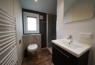 Baño moderno en Kids Adventure cottage, Kaatsheuvel, Países Bajos, con inodoro, lavabo y ducha.