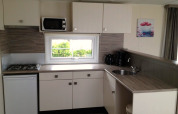Kitchenette moderne dans l’hébergement glamping Berkel 6 avec gazinière, micro-ondes et cafetière.